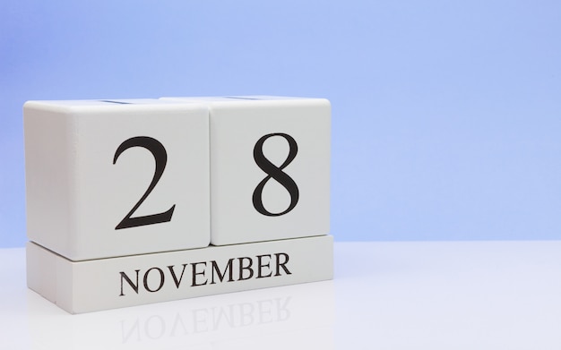 November 28st. Day 28 of month, daily calendar on white table with reflection