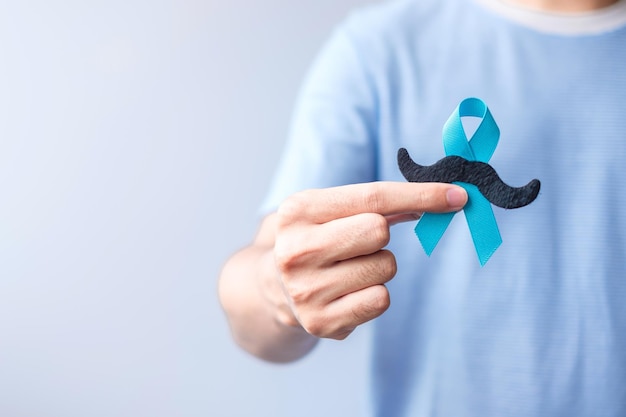 November prostate cancer awareness month blue ribbon with\
mustache for supporting people living and illness healthcare\
international men father and world cancer day concept