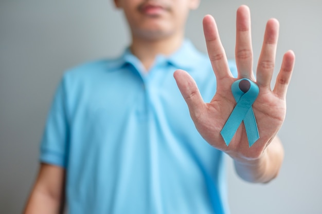 November Prostate Cancer Awareness month, Man in blue shirt with hand holding Blue Ribbon for supporting people living and illness. Healthcare, International men, Father and World cancer day concept