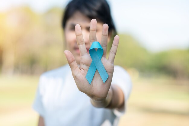 Foto novembre mese della consapevolezza del cancro alla prostata, donna che tiene il nastro blu per sostenere le persone che vivono e le malattie. sanità, uomini internazionali, padre, giornata mondiale del cancro e concetto di giornata mondiale del diabete