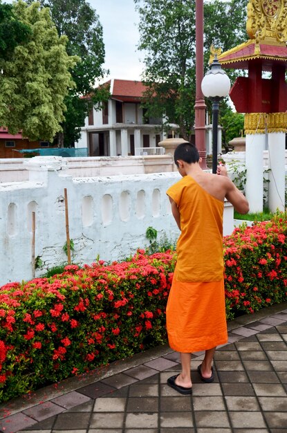 Photo novice monk use sweep cleaning front of ubosot or church at wat phu mintr or phumin temple in morning time on july 26 2016 in nan thailand