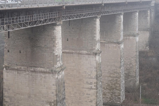 Novoplanivsky bridge supports over the canyon of the Smotrych River The old bridge of the 19th century in foggy weather KamianetsPodilskyi Ukraine