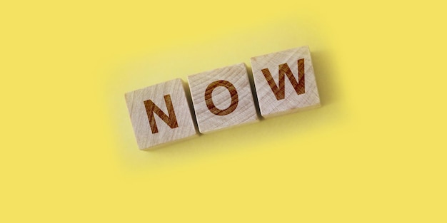 Now text word cube on yellow background