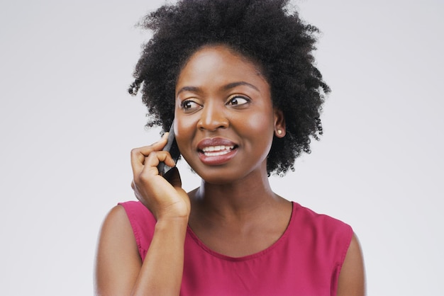 Now theres a familiar voice Studio shot of a young woman using a mobile phone against a grey background