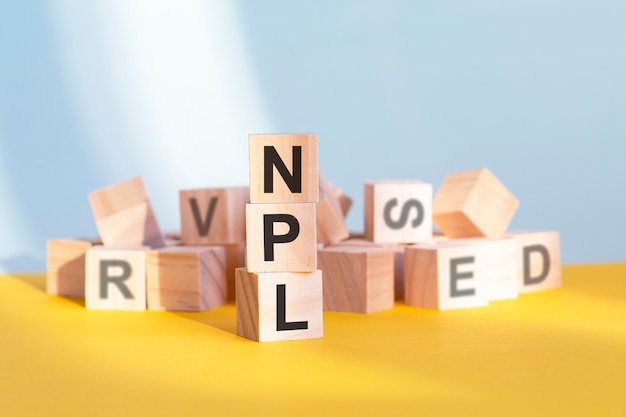 NPL-不良債権-木製の立方体に関する言葉。ビジネスと金融の概念。