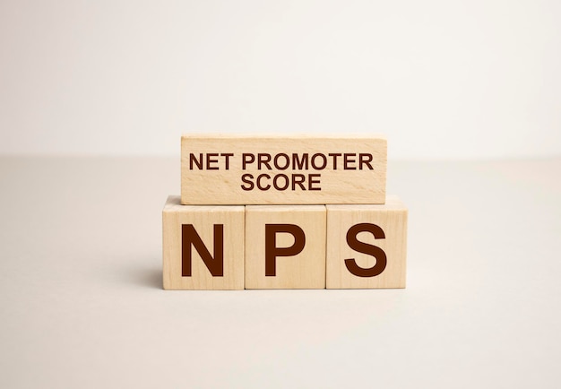 NPS as NET PROMOTER SCORE Conceptual image text on wood cubes text in black letters on wood blocks