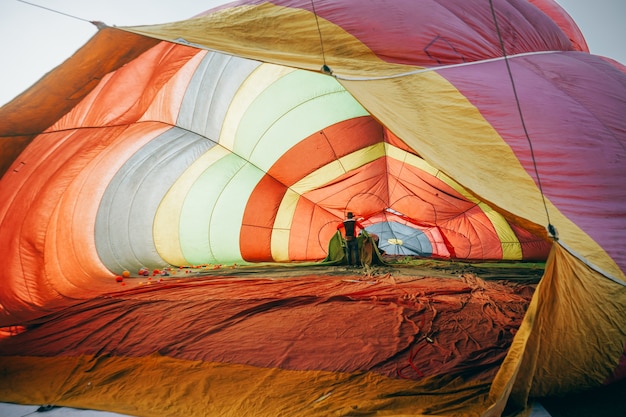 Nside de kleurrijke hete luchtballon die op grond ligt