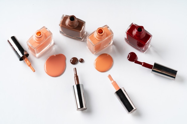 nude colors nail polish spilled over white background