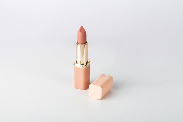 흰색 배경에 모자가 달린 누드 매트 립스틱 립 메이크업을 위한 여성 액세서리 컴포지션 배경에서 메이크업 아티스트를 위한 전문 화장품
