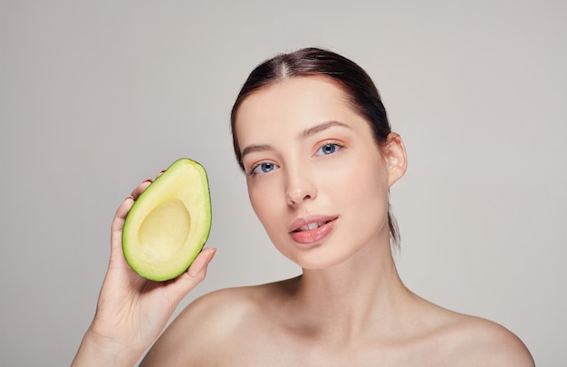 Nude perfect skin lady with avocado in the right hand