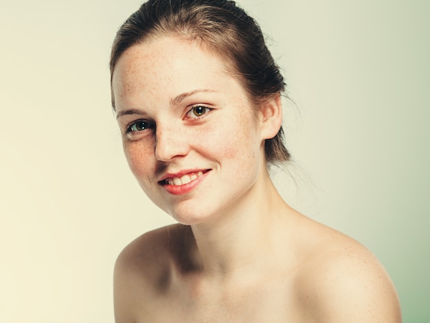 Nude shoulders beautiful freckles woman face portrait young. blue background