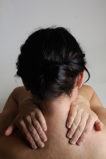 Nude woman with a back pain