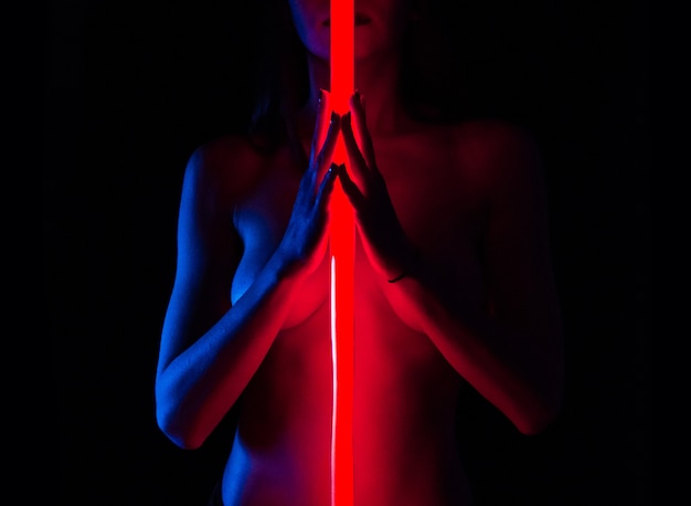 Giovane donna nuda con luci al neon