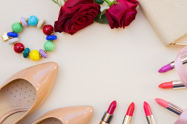 Nudekleurige schoenen met hoge hakken met lipsticks en portemonnee hero header