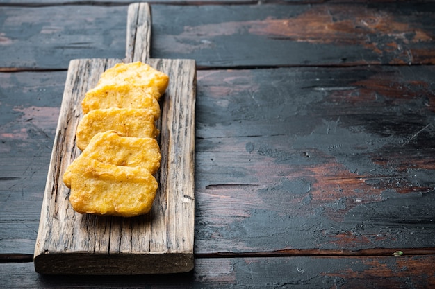 Foto pepite impanate sulla vecchia tavola di legno scuro, con lo spazio della copia.