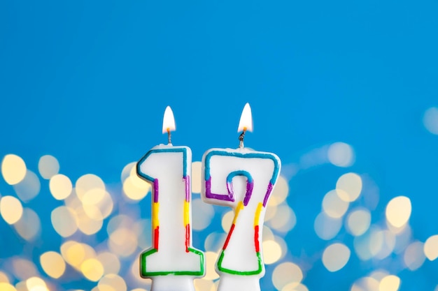 Фото Свеча празднования дня рождения номер 17 на ярком свете и синем фоне