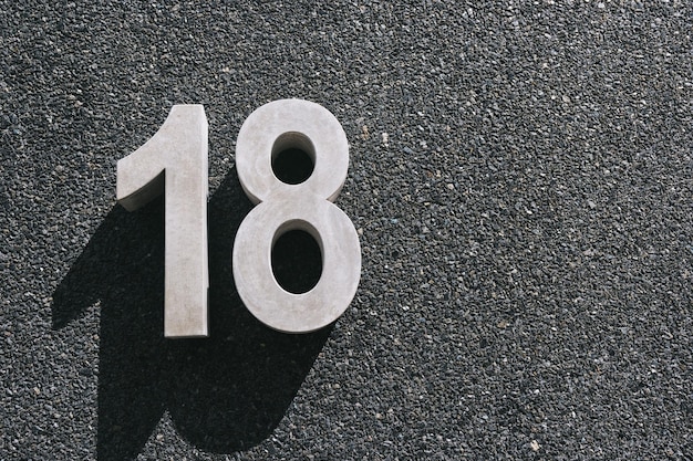 Фото Номер 18 висит на черной бетонной стене