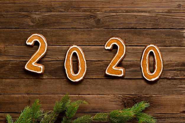 Number 2020 made from gingerbread cookies on a wooden background. 