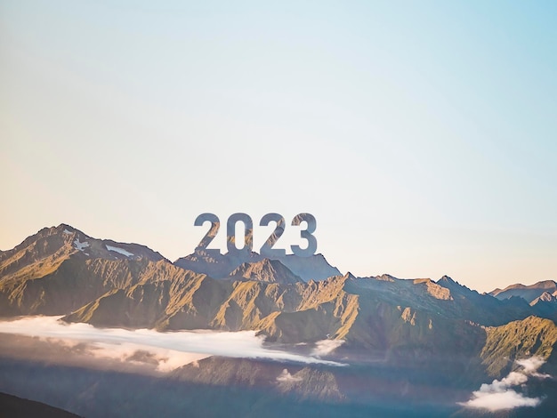 A number 2023 on the mountain peak happy new year success and freedom concept