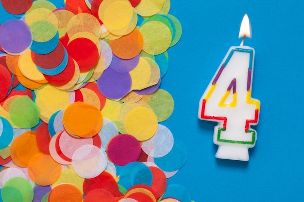 Number 4 celebration candle with party confetti