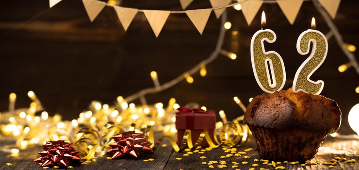 Photo 62 黄金の祭り ケーキの中に燃えるろうそく 木製の祝日の背景 62 誕生日を祝う 誕生日の祝いの概念 バナー