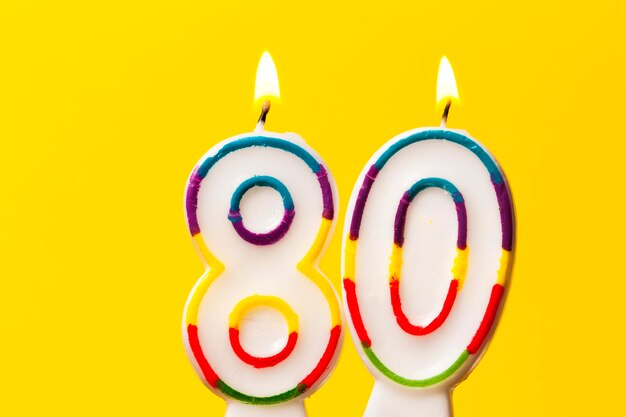 사진 밝은 노란색 배경에 번호 80 생일 축하 촛불