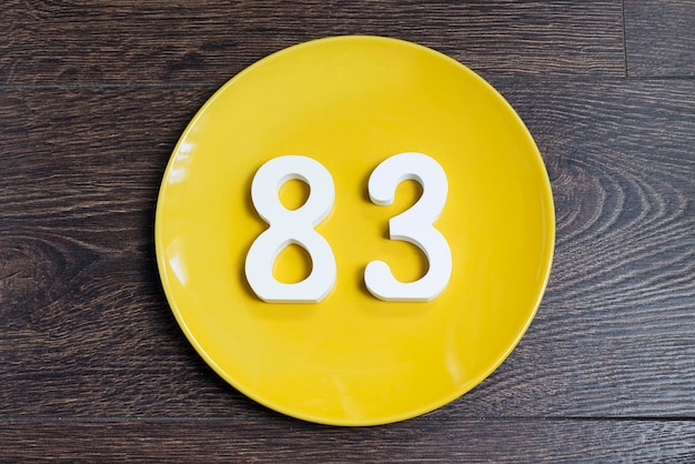 The number eightythree on the yellow plate