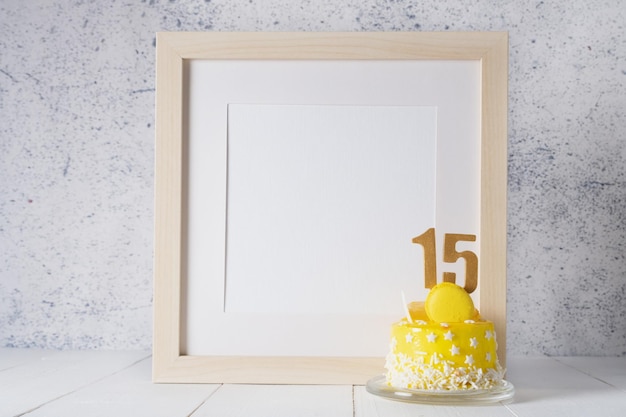 The number Fifteen on the yellow cake next to the white frame mockup with copy space