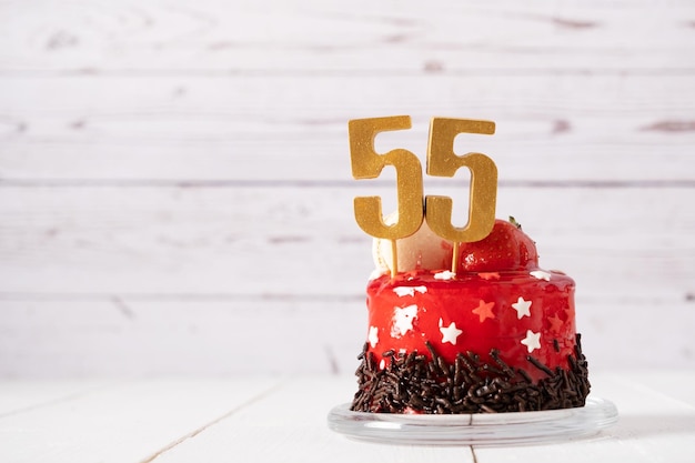 The number Fifty five on a red birthday cake on a light background