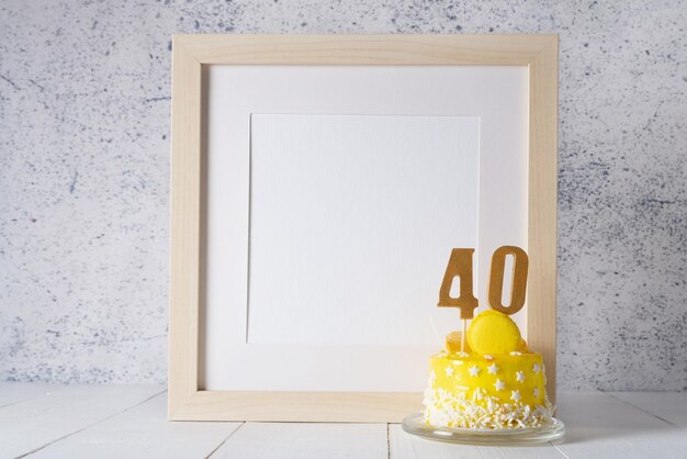 The number Forty on the yellow cake next to the white frame mockup with copy space