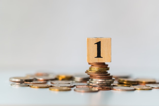 Number one wooden block on pile of coins 