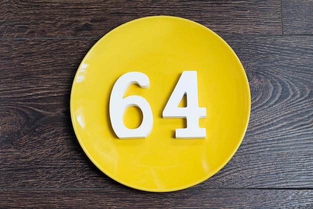 The number sixtyfour on the yellow plate