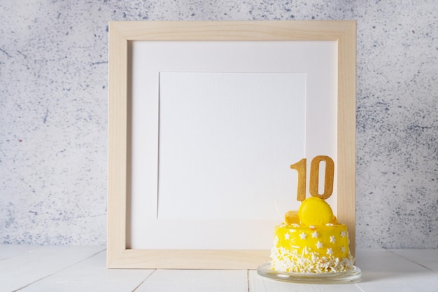 The number Ten on the yellow cake next to the white frame mockup with copy space