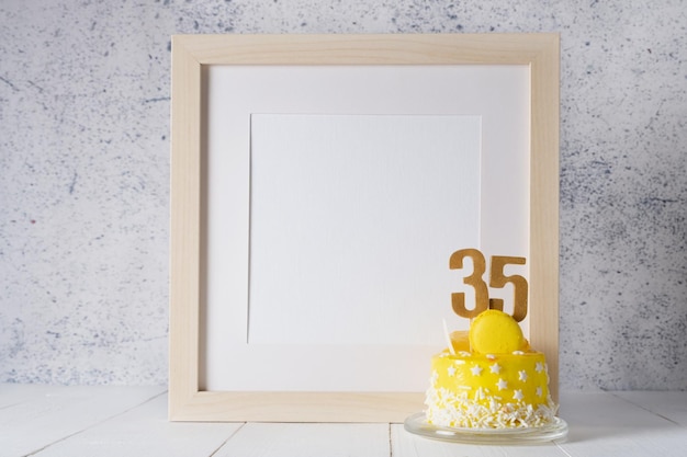 The number Thirty five on the yellow cake next to the white frame mockup with copy space