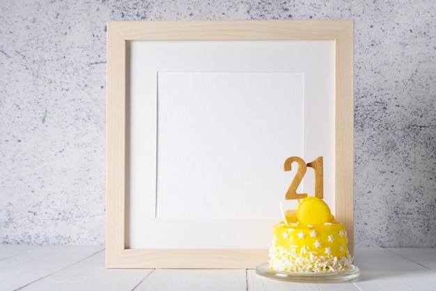 The number Twenty one on the yellow cake next to the white frame mockup with copy space