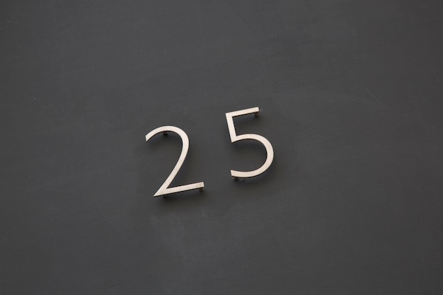 Number TwentyFive on Black Wall on Diagonal Tilt