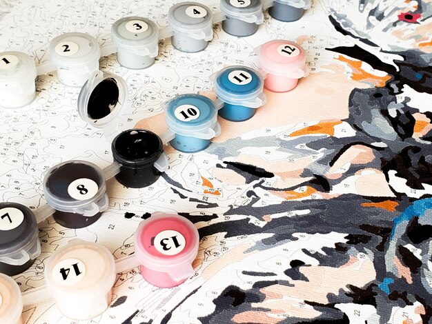 Numbered paint jars for drawing pictures by numbers. Creative hobby