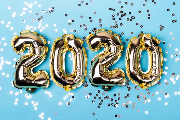 Numbers 2020 made from foil balloons on blue sparkles background