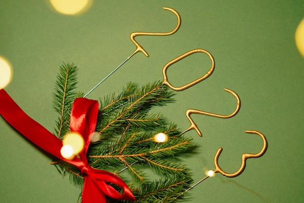 写真 番号 2023 クリスマス ツリーの枝赤い弓と緑の無地の背景にお祭りの提灯