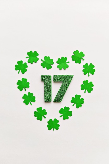Numeral 17 on white background with heart frame of papercut fourleaf clover leaves