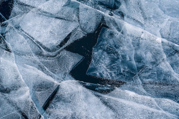 Numerous streaks of cracks in the transparent magnificent blue clear ice. Horizontally. Baikal Lake, Russia