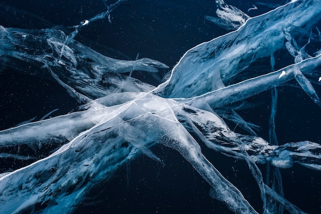 Numerous streaks of cracks in the transparent magnificent blue clear ice. Horizontally. Baikal Lake, Russia