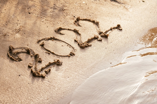 Nummer 2022, getekend op nat zand aan de kust. Prettige kerstdagen en gelukkig nieuwjaar concept