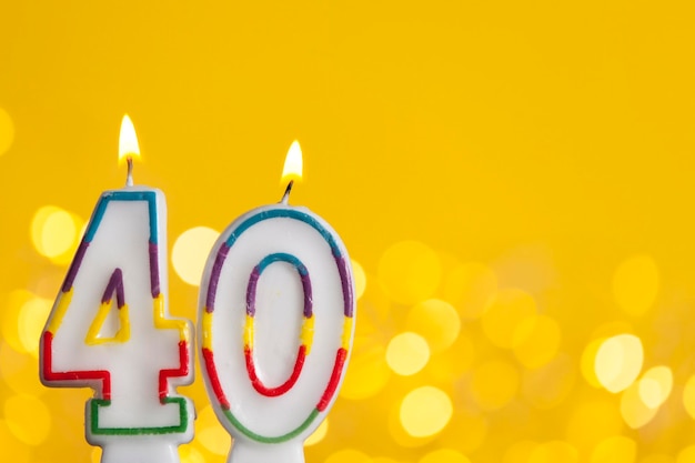 Nummer 40 verjaardagsviering kaars tegen felle lichten en gele achtergrond