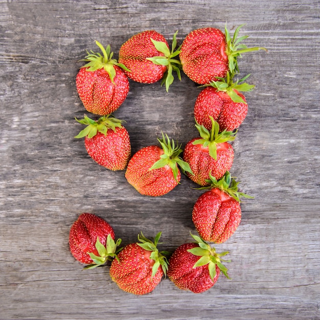 Nummer 9 van aardbeien op houten achtergrond