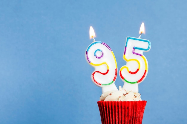 Nummer 95 verjaardagskaars in een cupcake tegen een blauwe achtergrond
