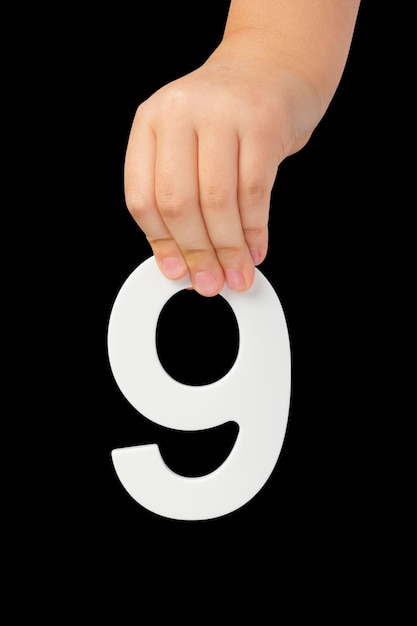 Nummer negen in de hand geïsoleerd op zwarte achtergrond nummer in de hand van een kind op een zwarte achtergrond om te zijn