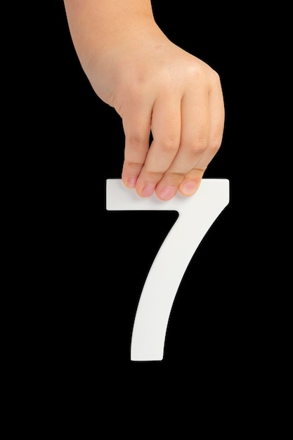 Foto nummer zeven in de hand geïsoleerd op zwarte achtergrond nummer in de hand van een kind op een zwarte achtergrond naar b