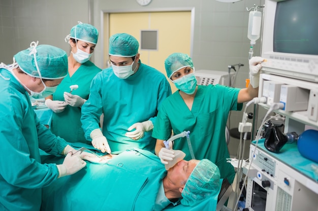 Nurse adjusting a monitor next to a patient