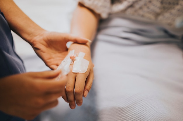 Nurse applying an IV drip to a patient